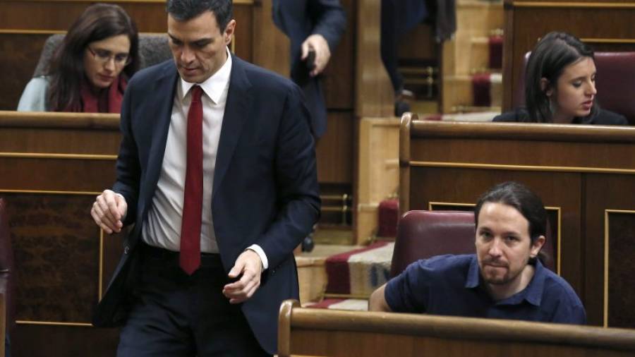 El secretario general del PSOE, Pedro Sánchez (i) pasa junto al líder de Podemos, Pablo Iglesias (d), durante la sesión constitutiva del Congreso.