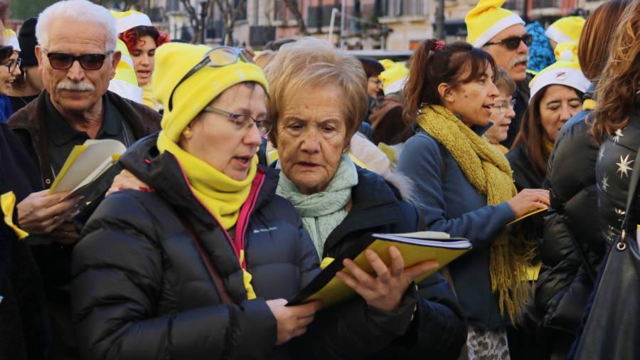 Pla mig de dues dones cantant abra&ccedil;ades a la cantada de nadales per la llibertat de Tarragona. FOTO: ACN