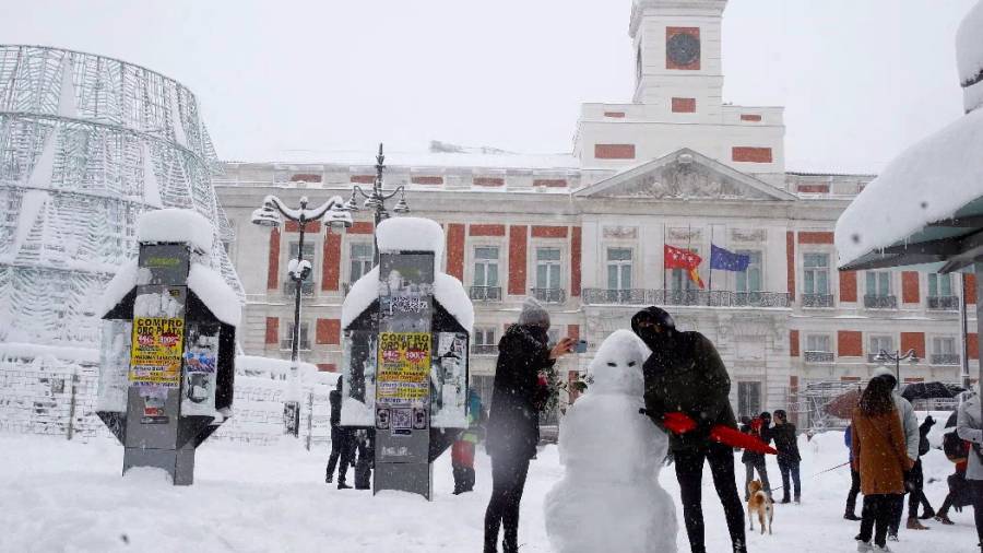 Una pareja hace un muñeco de nieve en la Puerta del Sol (EFE)