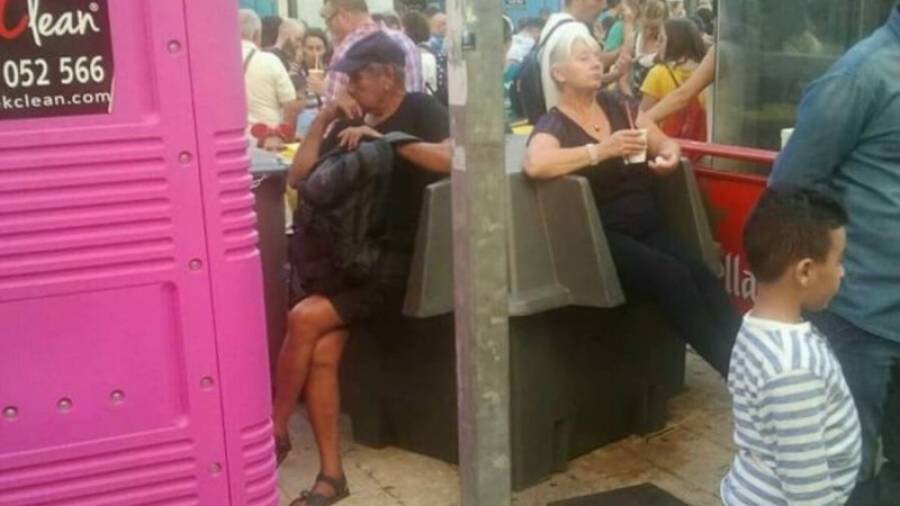 Los dos turistas sentados en los urinarios de la Plaça de la Font. Foto: Cedida