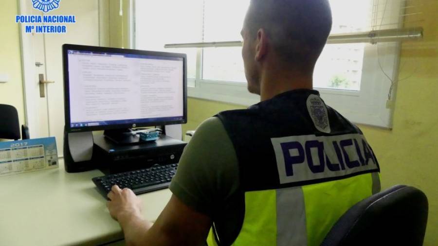 Un agente de la Policía Nacional mirando en su ordenador la web en la que el detenido intertaba sus anuncios. FOTO: DT