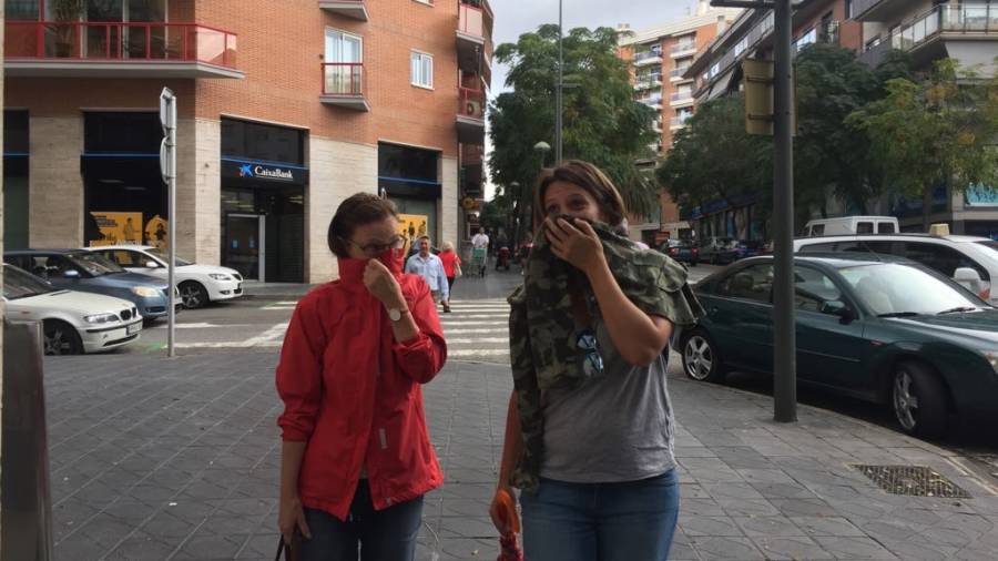 Dos mujeres, esta ma&ntilde;ana caminando con precauci&oacute;n en Tarragona.