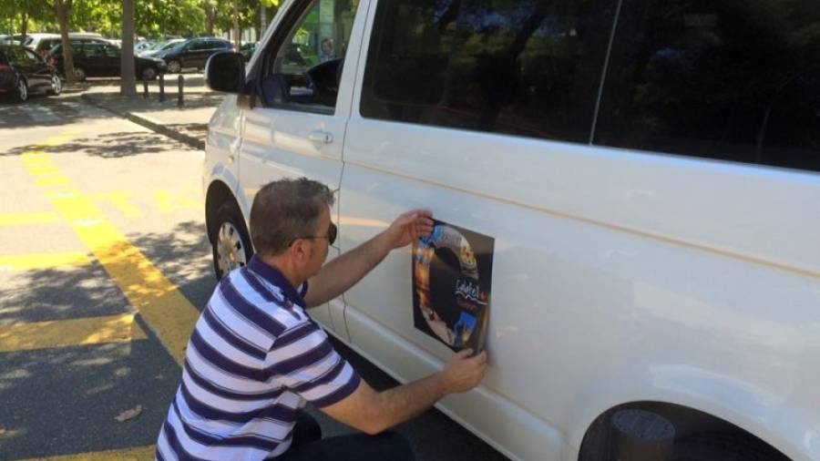 Un taxista coloca el logo que identificará a los profesionales con licencia. Foto: DT