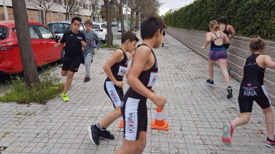 Deportistas de triatlon entrenando en la calle.