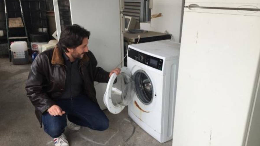 El concejal Antoni Martínez revisa una lavadora en la deixalleria.