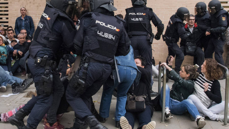 La Policía Nacional que ha requisado las urnas en el ambulatorio del barrio leridano de Cappont forcejea con unos ciudadanos. Foto: EFE