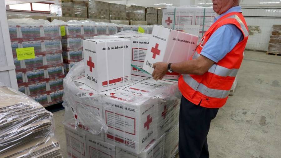 Un voluntario trabaja en el almacen de alimentos de la entidad. Creu Roja tiene 2.667 voluntarios y 147 técnicos en la demarcación. Foto: Lluís Milián