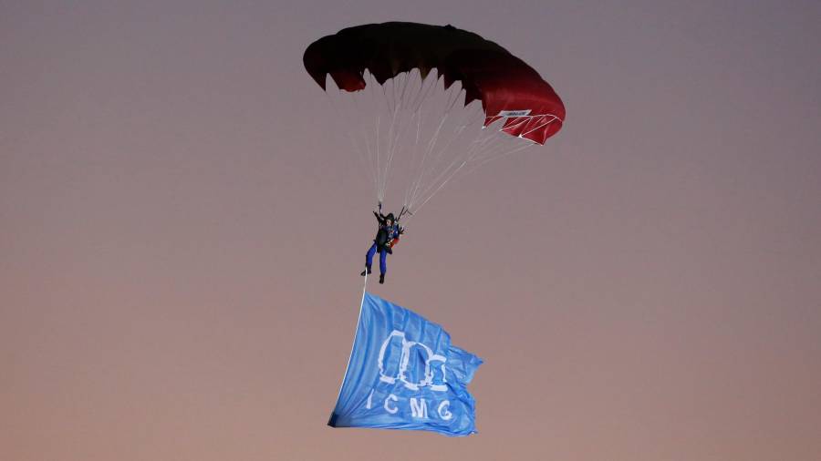 Una paracaigudista aterra al Nou Estadi amb la bandera olímpica.PERE FERRE