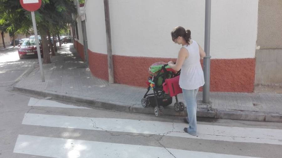 Susana Bujalance tiene que levantar el carro de su bebé para poder acceder a la acera de la calle del Vent. Foto: Javier Díaz