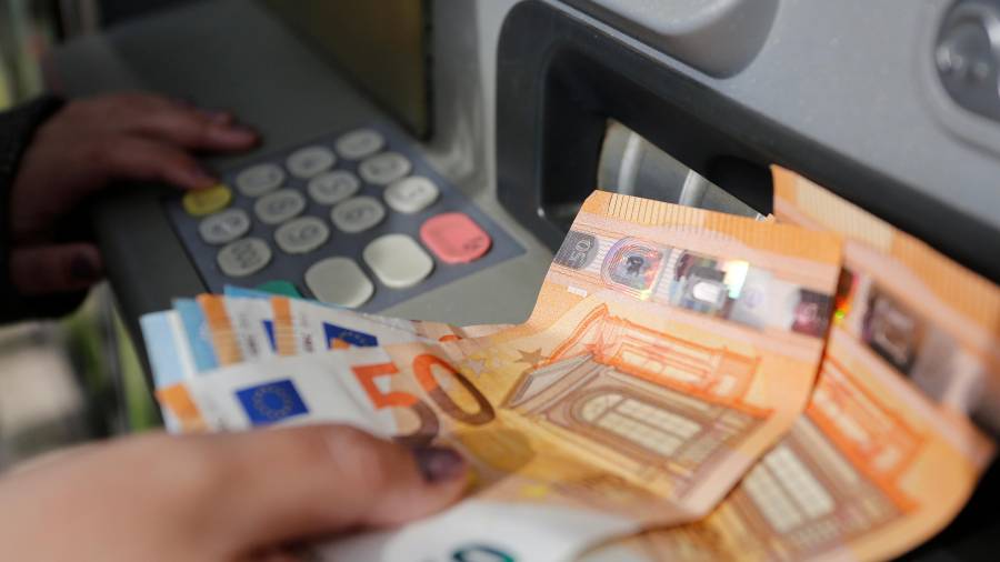Imagen de recurso de una persona sacando dinero de un cajero automático.