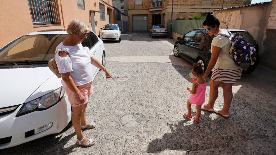 Pilar y Raquel, en la puerta de su casa, mostrando los socavones de la calle y denunciando las dificultades con las que se encuentran. Foto: Pere Ferré