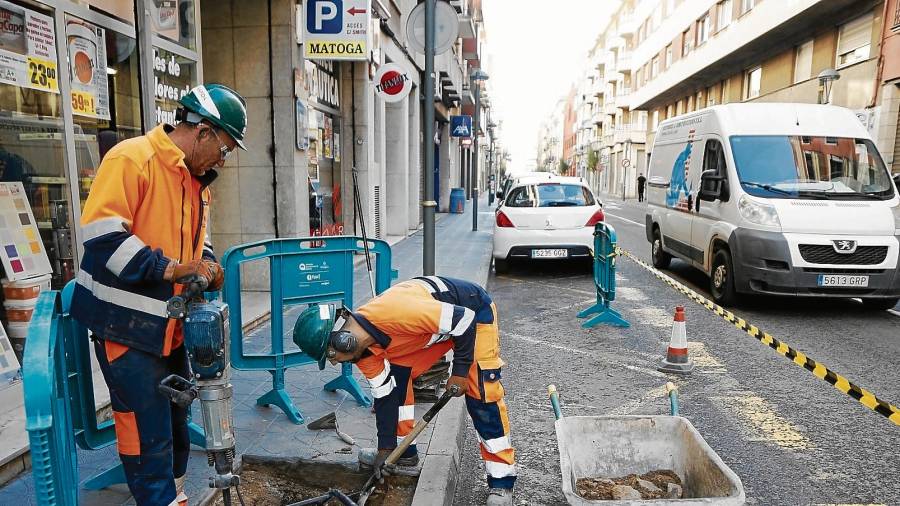 Operarios de la Brigada Municipal arreglando los alcorques de la calle Reial, el pasado viernes. FOTO: pere ferré