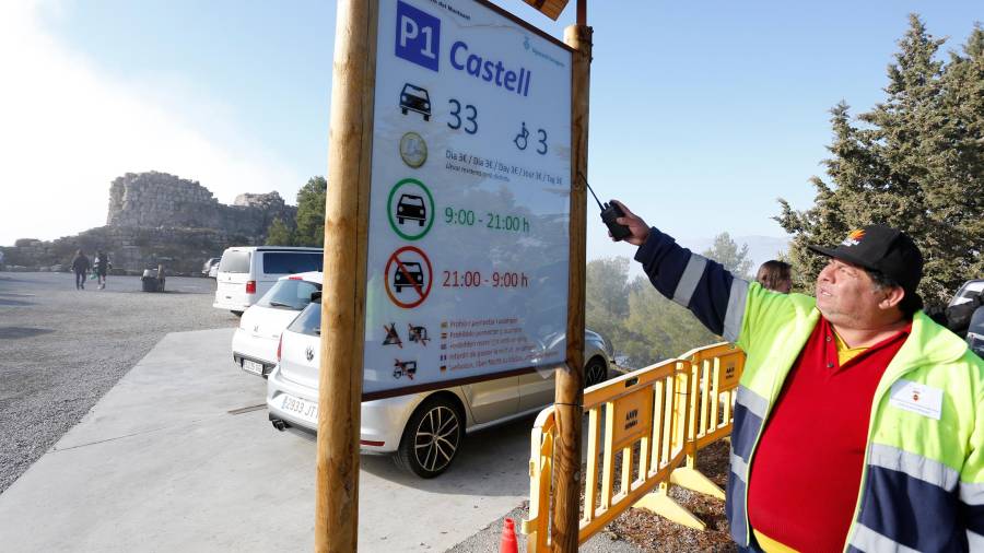 Persi Saracho mostra el cartell instal·lat a l’aparcament de Siurana, on s’informa del preu i els horaris. FOTO: Pere Ferré