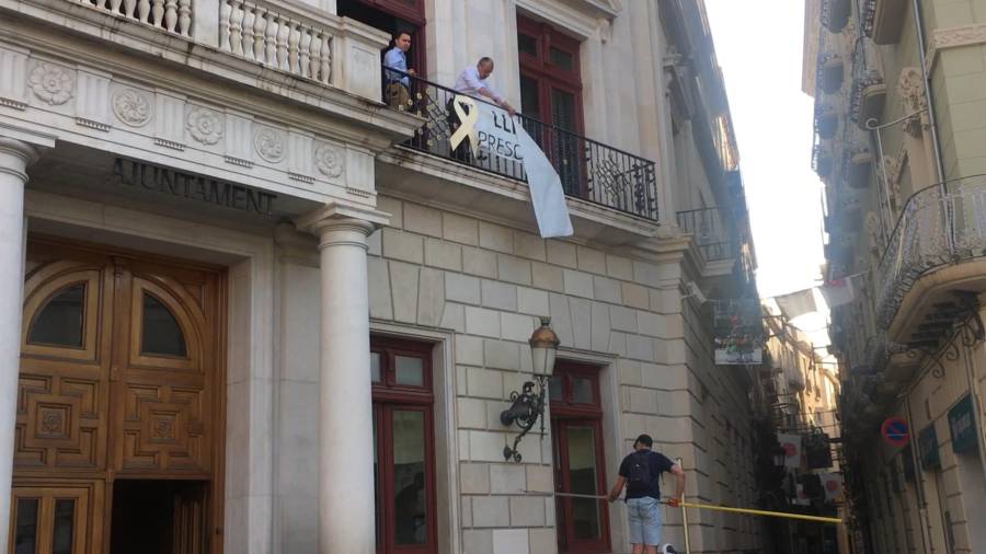 Imagen del momento en que retiraban la pancarta mientras el alcalde de Reus intentaba evitarlo. DT
