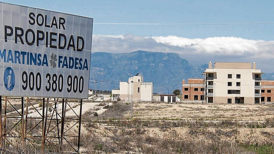 El cartel de Martinsa Fadesa, que quebró hace diez años. Al fondo, la urbanización fantasma del Mirador del Ebro, en L’Aldea. FOTO: Joan Revillas