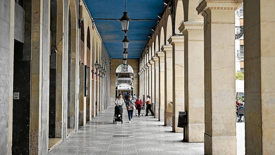 Gent passejant per l’interior del porticat de la plaça de Prim de Reus. FOTO: Alfredo González