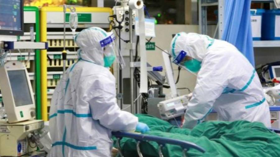Imagen de dos trabajadores sanitarios atendiendo a un paciente con coronavirus. EFE