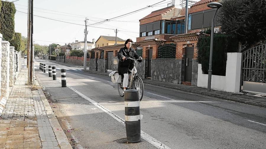 Una vecina del barrio de la Llosa pasea con su bici por la calle Orquídies, que tiene las aceras deterioradas. FOTO: FABIÁN ACIDRES