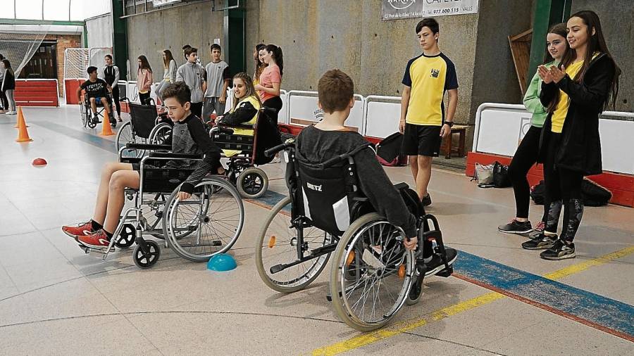 Alguns dels alumnes realitzant el circuit amb cadira de rodes al Pavelló del Vilar. FOTO: A.T.