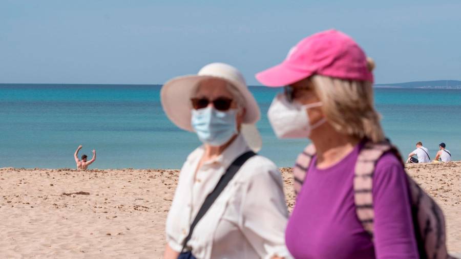 Dos mujeres paseando con mascarilla al lado de la playa. Foto: EFE