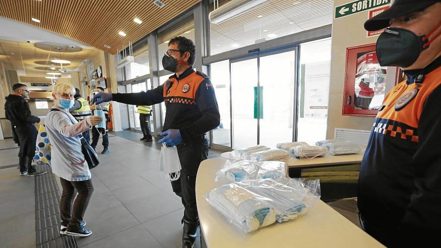 Voluntarios de Protecció Civil entregando mascarillas en la estación de tren de Tarragona en abril de 2020. FOTO: PERE FERRÉ