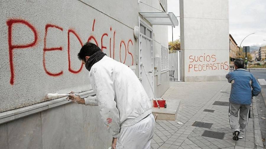 Un operario tapa una pintada en una parroquia de Granada, donde se denunciaron abusos, en 2014. efe