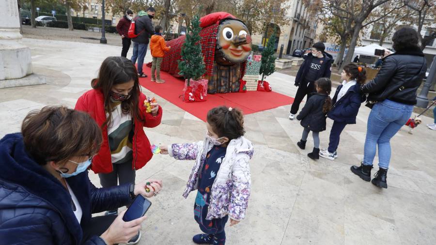 El Tió XL estuvo ayer por la mañana en la Plaça dels Carros y cagó caramelos a los niños que se atrevieron a pegarle. FOTO: pere ferré