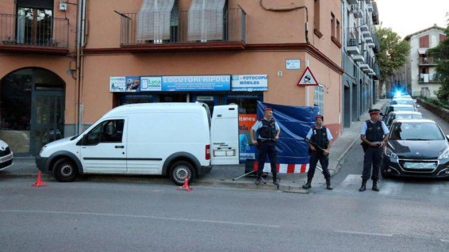 Agentes de los Mossos d’Esquadra custodian el locutorio de Ripoll que registraron. La detención de su dueño se prolonga 72 horas. Foto: ACN