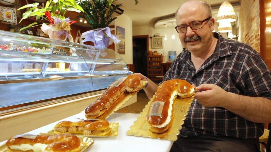 Josep González, ayer, en su pastelería, con los bastones dulces y el bocadillo. FOTO: PERE FERRÉ