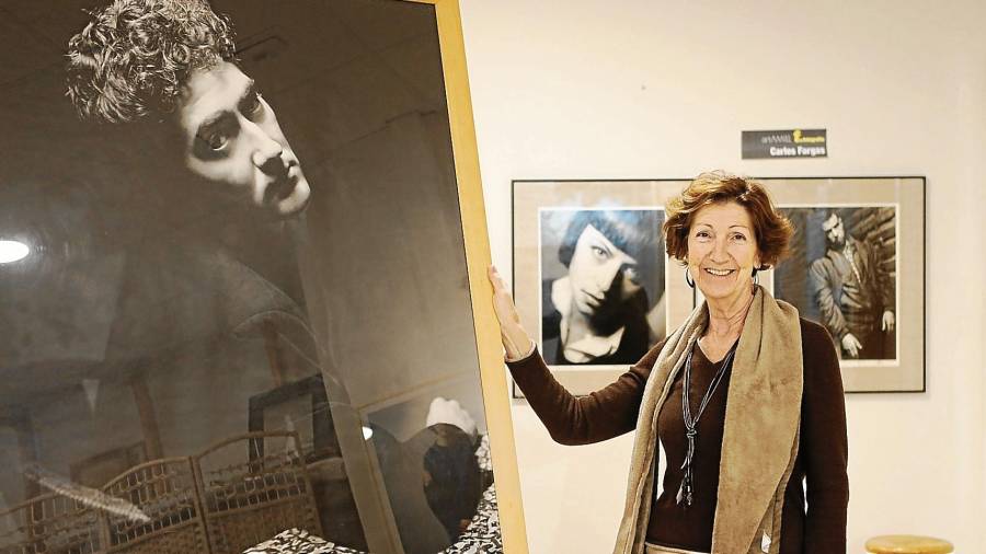 Elena Padrell amb una fotografia d’un joveníssim Quim Monzó, en el marc de l’exposició ‘F de