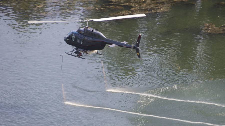 L’helicòpter arruixant tractament contra la mosca negra i el mosquit, la setmana passada. Foto: Joan Revillas