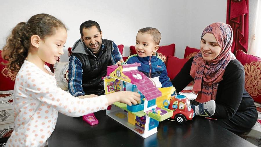 Hayat Afarrich con su marido y sus hijos de 6 y 2 años, jugando en su piso de Campclar, ayer por la tarde. FOTO: Alba Mariné