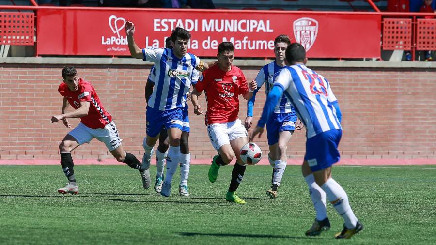 Montero conduce el balón bajo la presión de dos jugadores del Figueres.