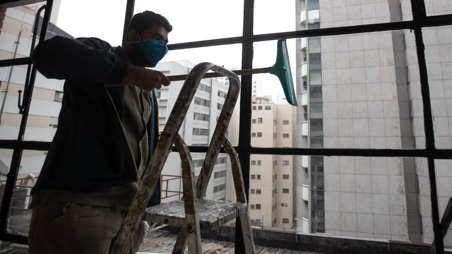 Un trabajador limpia las ventanas de un edificio. Foto: EFE