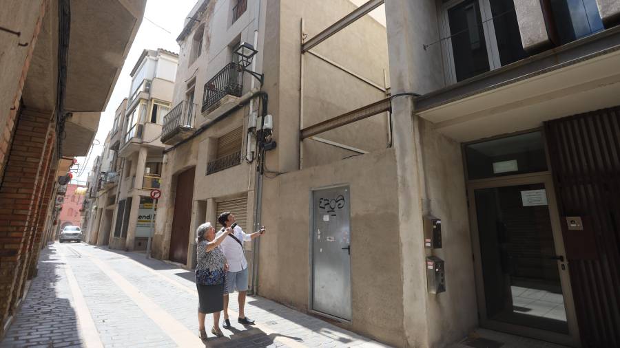 La propietària de la casa acompanyada pel seu fill, davant de l’espai que ocupava l’habitatge. FOTO: Alba Mariné