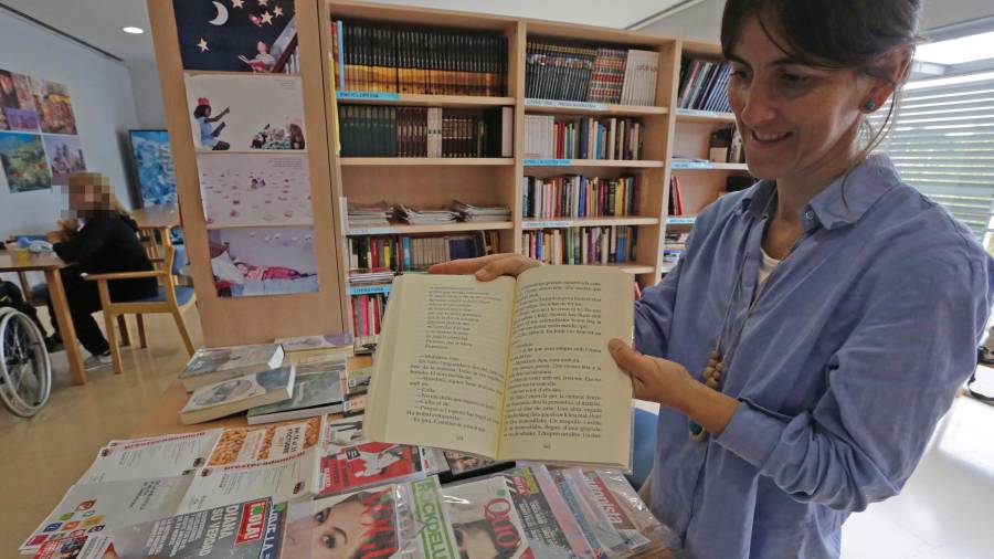 La bibliotecaria Cristina Segura muestra uno de los libros de letra grande que ofrecen. FOTO: Lluís Milián
