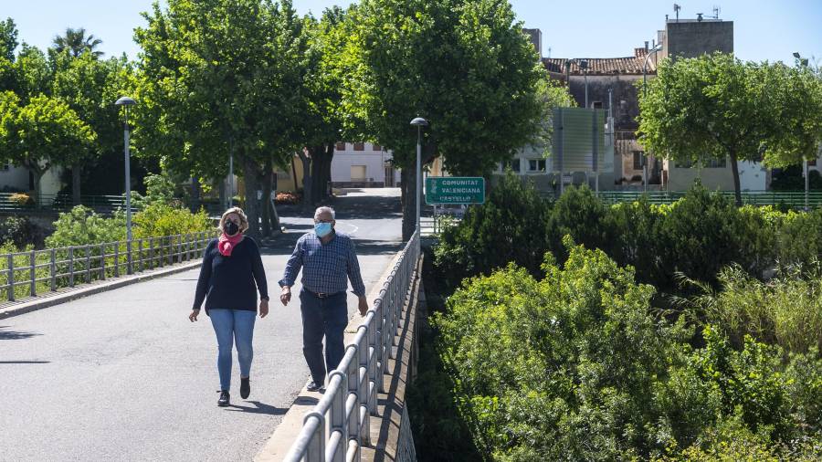 Eli Itarte i Juan Francisco Fuentes caminant pel pont sobre el riu Sénia. FOTO: JOAN REVILLAS