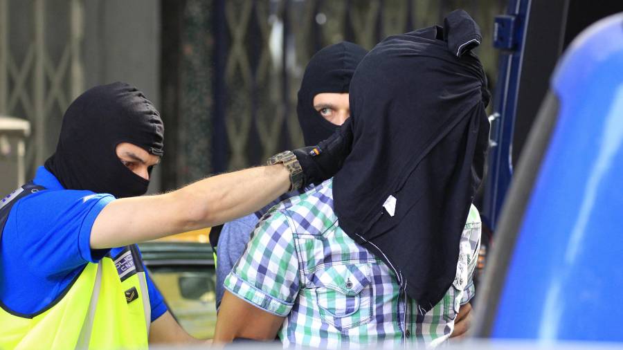 Agentes de la Policía Nacional trasladan a uno de los tres presuntos yihadistas marroquíes detenidos esta madrugada en Madrid. Foto: EFE
