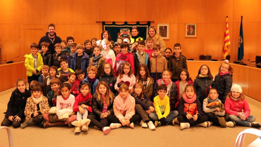 Foto de família dels alumnes, professors i alcaldessa al saló de plens de Cambrils.