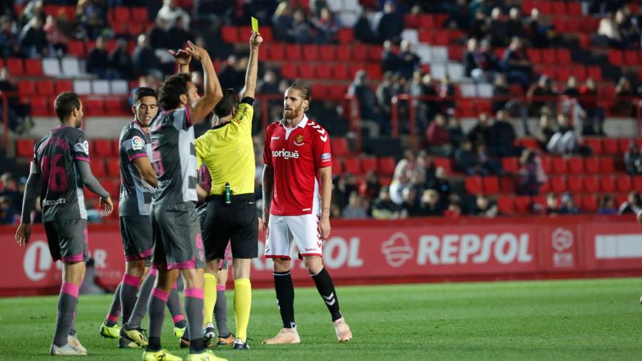 El árbitro Sagues Oscoz muestra la cartulina amarilla a Raúl Albentosa en el partido Nàstic-Granada. FOTO. PERE FERRÉ