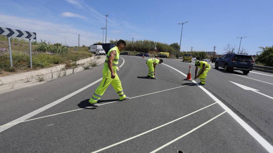 Operarios pintando el carril interior (que ha quedado anulado) el viernes pasado. FOTO: PERE FERRÉ