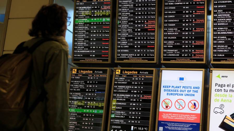 Un pasajero mira los paneles de información del aeropuerto Adolfo Suárez Madrid-Barajas en los que varios vuelos aparecen retrasados o desviados este lunes. EFE