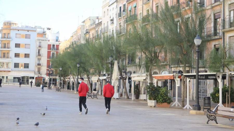 Imagen de dos jóvenes en la Plaça de la Font de Tarragona, vacía tras el cierre de bares y restaurantes. DT