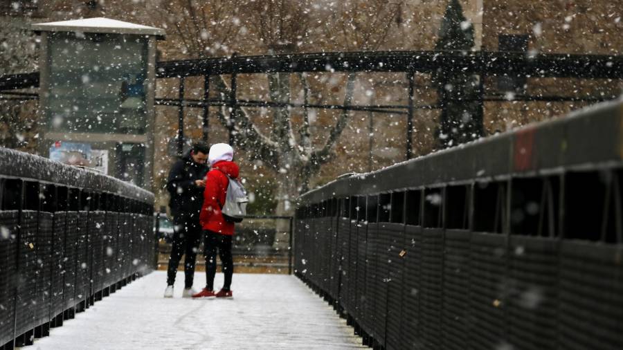 Dos adolescents sota la neu al pont de Tordera. FOTO:acn