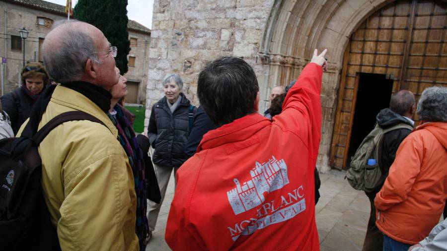 Un guia donant explicacions a un grup de turistes de visita al patrimoni medieval de Montblanc. FOTO: ACN