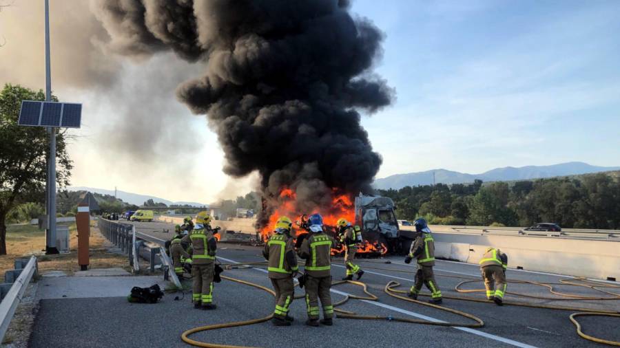 Varios bomberos apagando el incendio que quema el camión accidentado en la AP-7 a la altura de Capmany (Alt Empordà)