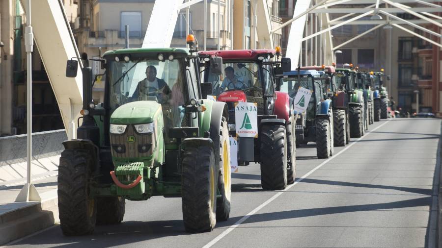 El grup de tractors travessant el pont de l’Estat de Tortosa, després de fer una marxa lenta per tota l’Avinguda Generalitat, ahir al migdia. FOTO: JOAN REVILLAS
