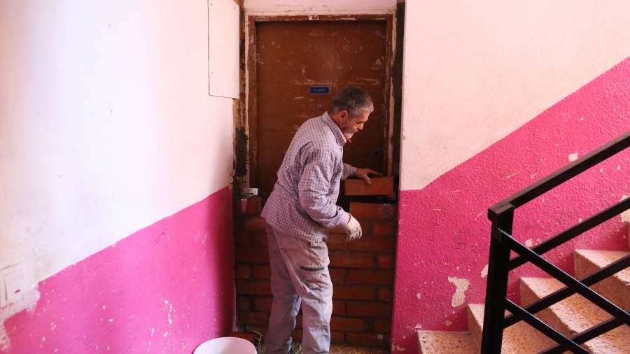 Un vecino de Mas Pellicer (Reus), tapia una puerta para evitar ocupas. Foto: Alba Mariné