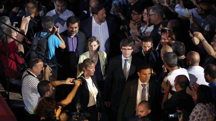 El presidente de la Generalitat, Carles Puigdemont (c, dcha), la presidenta del Parlament, Carme Forcadell (c, izq), y el líder de ERC, Oriol Junqueras (detrás) llegan al Tarraco Arena. Foto: ACN