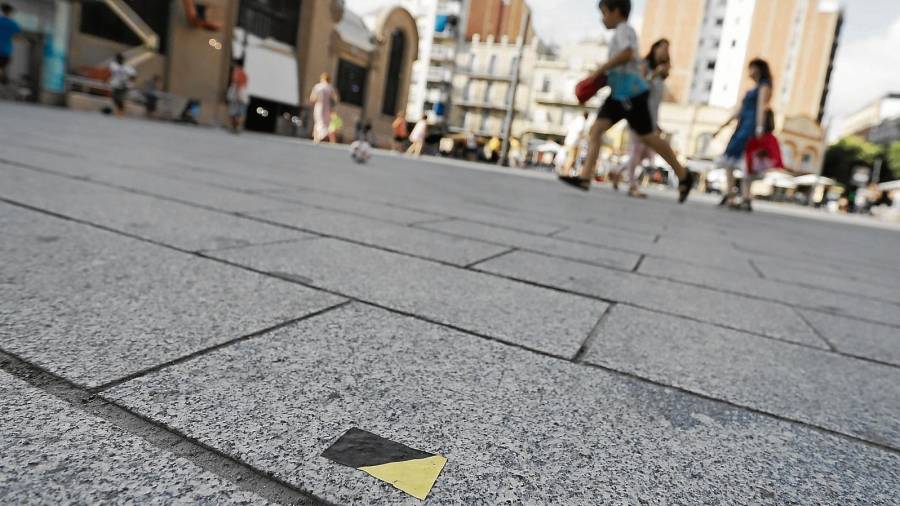 Las marcas en el suelo que indican el puesto que deben ocupar los marchantes en la Plaça Corsini. FOTO: Pere Ferré